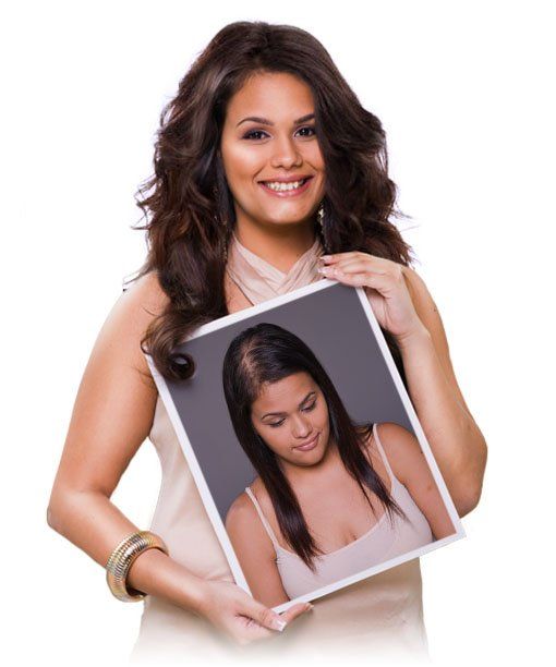 Woman holding a framed portrait of a smiling woman with dark hair against a white background